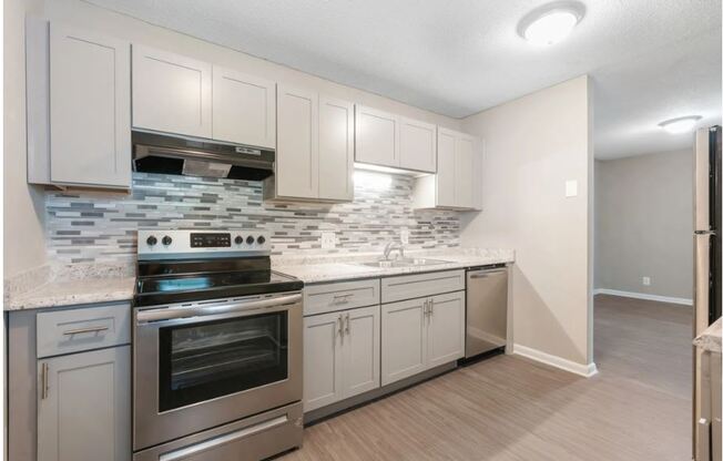 a kitchen with stainless steel appliances and white cabinets