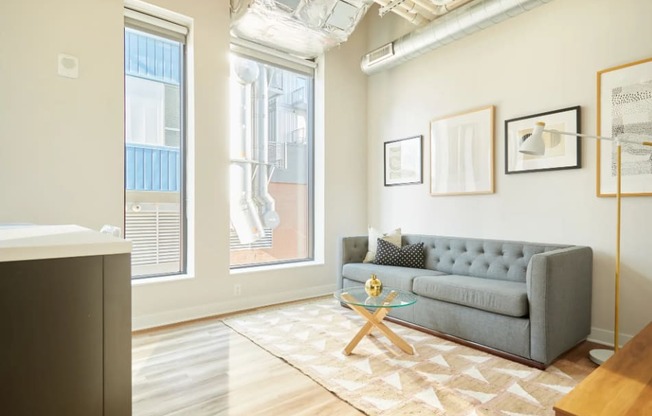 a living room with a couch and a table     and a window