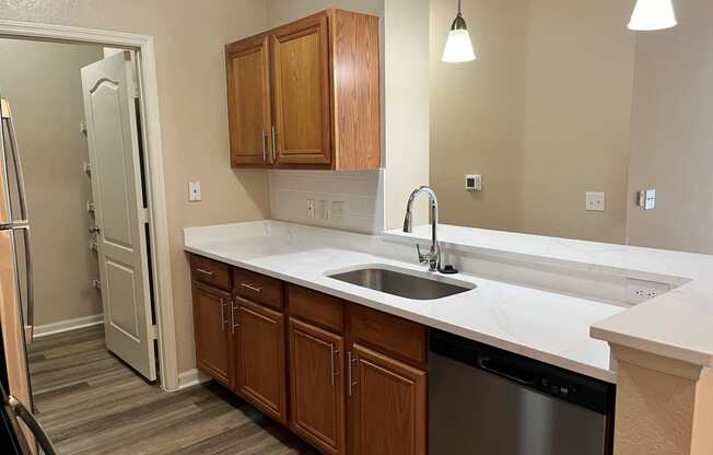 an empty kitchen with a sink and a refrigerator