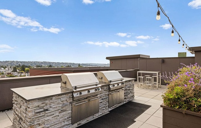 A stone outdoor kitchen with a grill and a table.