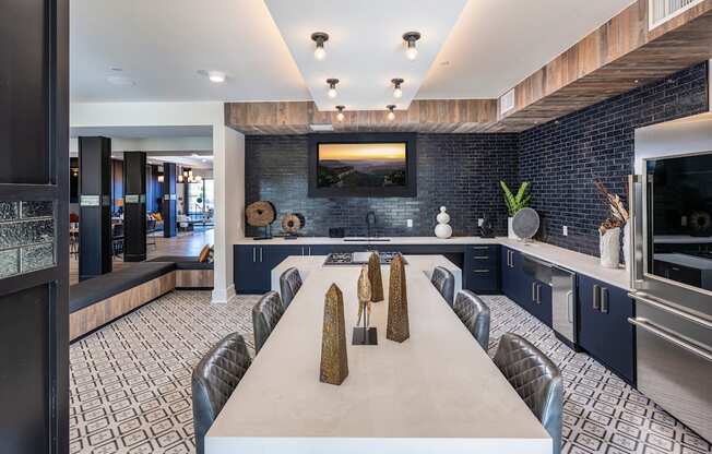 Icon at Cooley Station-Clubhouse with a long white table in a kitchen with blue cabinets