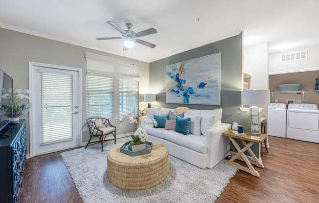 a living room with a white couch and a ceiling fan