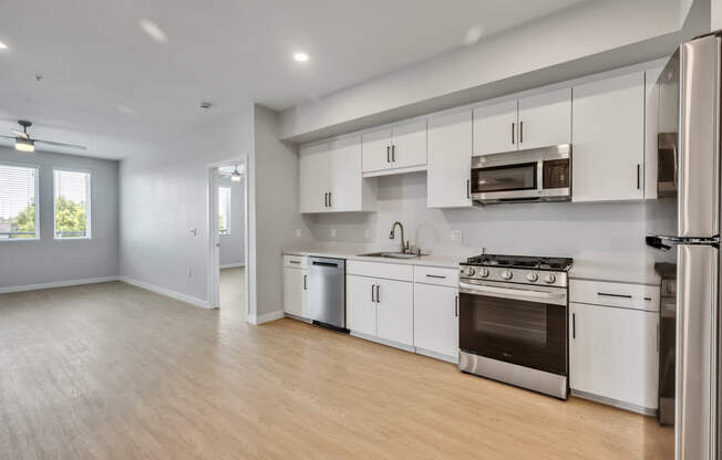 A modern kitchen with white cabinets and stainless steel appliances.