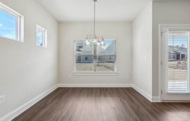 A room with a large window and a wooden floor.