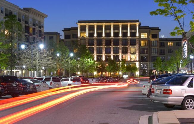 Cars are parked on the side of the road at night.