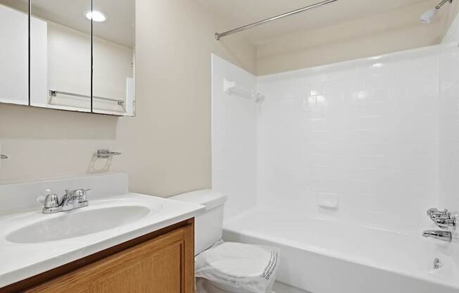 A white bathroom with a sink, toilet, and bathtub.