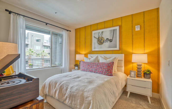 a bedroom with an orange accent wall and a bed