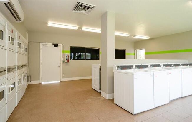 a room filled with lots of white washers and dryers