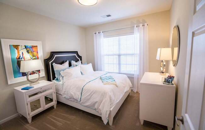 A bedroom with a bed, nightstand, and lamp.