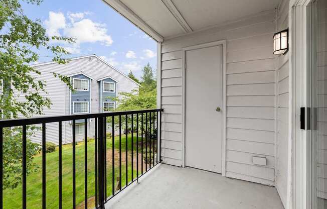 A white door is on the porch of a house.