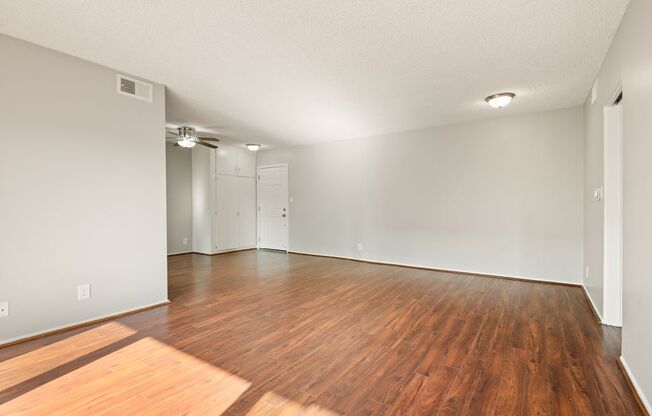 A room with wooden flooring and white walls.