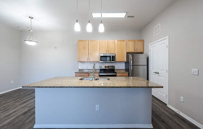A kitchen with a granite countertop and wooden cabinets.
