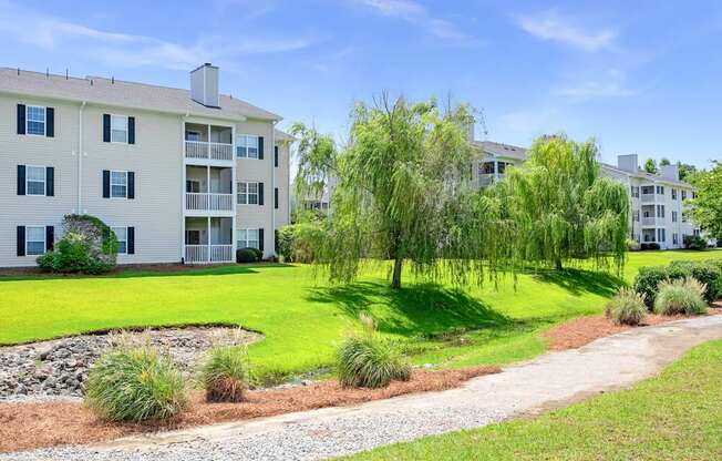 A white apartment building with a green lawn in front.