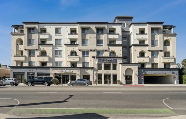 a street view of a building with cars parked in front of it