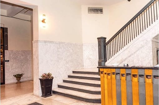 the lobby of a building with a staircase and a plant