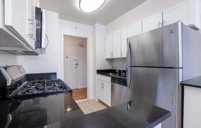 A kitchen with a stove top oven and a refrigerator.