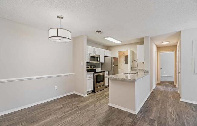 an open kitchen and living room with a marble counter top