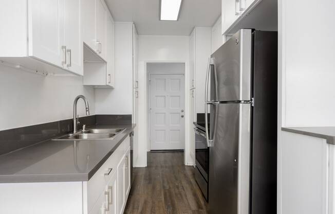 a kitchen with stainless steel appliances and white cabinets