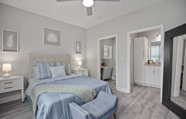 A bedroom with a bed, nightstand, and chair.