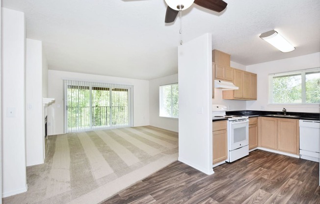 an empty kitchen and living room with a ceiling fan