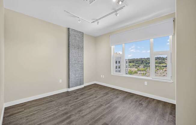 A room with a large window and a wooden floor.