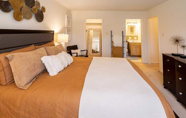 A bedroom with a large bed and a mirror on the wall.