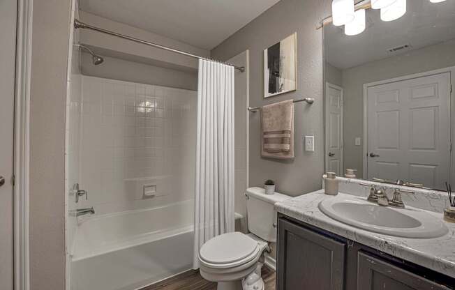 A white toilet sits in a bathroom next to a sink.