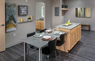 A modern kitchen with a dining table set for two.
