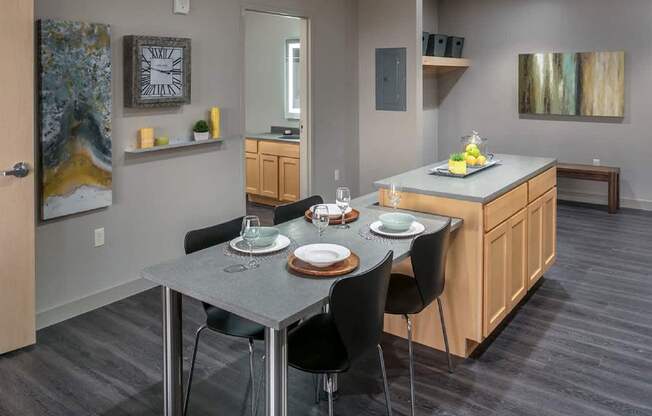 A modern kitchen with a dining table set for two.