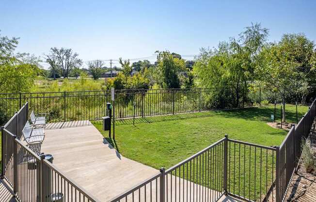 A backyard with a deck and a metal fence.