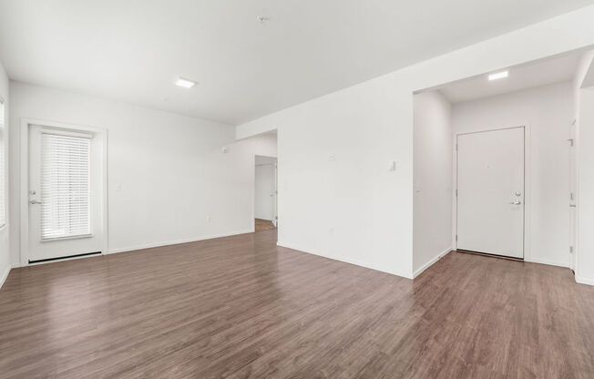 a bedroom with hardwood floors and white walls