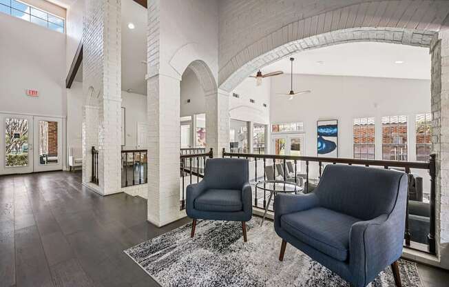 A spacious lobby with two chairs and a patterned rug.