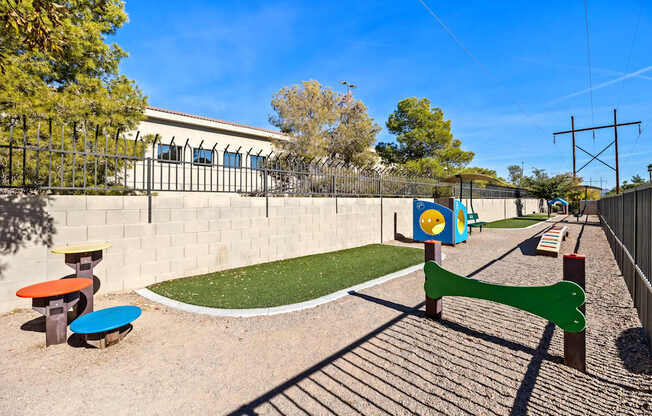A playground with a green slide and a blue and yellow play structure.