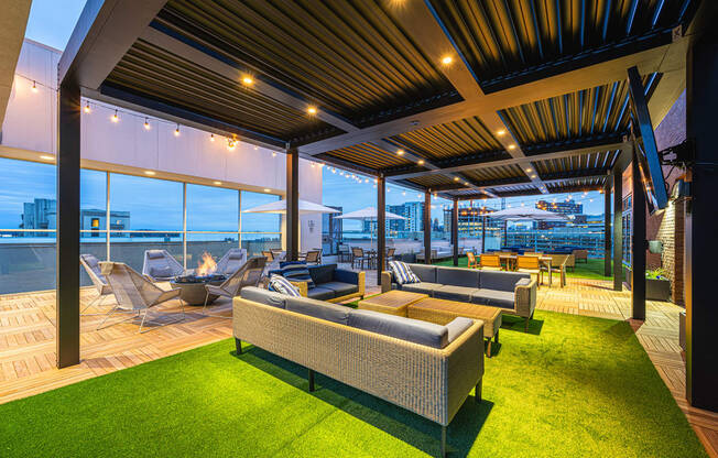 a roof top terrace with couches and chairs and a view of the city