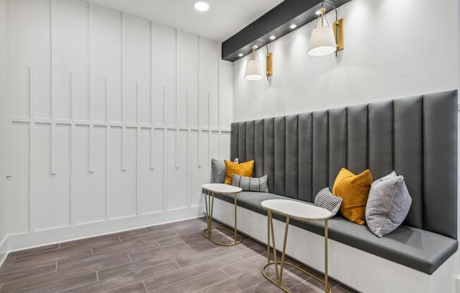 a seating area with two tables and pillows in a room with white lockers