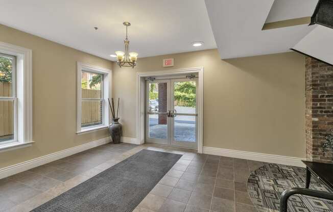 an empty entryway with a brick wall and a glass door at The Granite Works Apartments , Buffalo