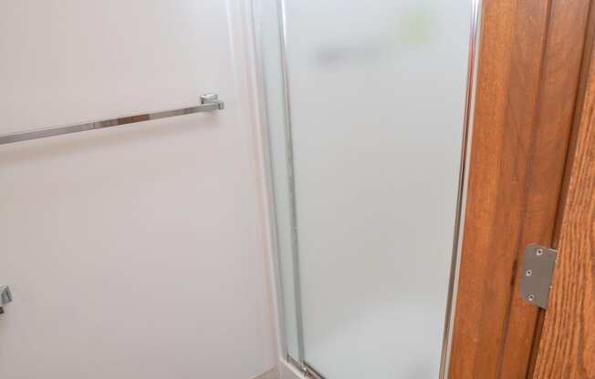 Walk In Showers With Built In Bench And Glass Enclosure at Raleigh House Apartments, MRD Apartments, Michigan, 48823