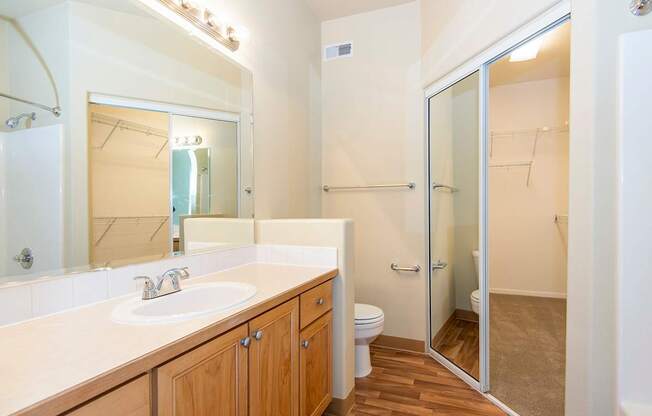 A bathroom with a sink, toilet, and shower.