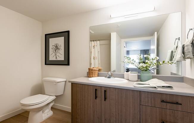 a bathroom with a toilet sink and mirror at QUINN BY VINTAGE, Shoreline, WA 98155