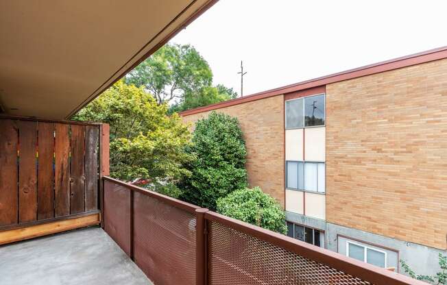 a balcony with a wooden fence and a brick building