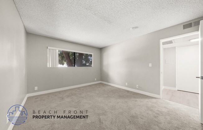 the spacious living room of a manufactured home with carpeting and a window