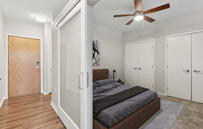 A bedroom with a bed, a ceiling fan, and a rug.