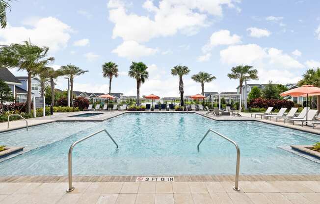 a large pool with chairs and palm trees at The Sophia, Venice, FL, 34275