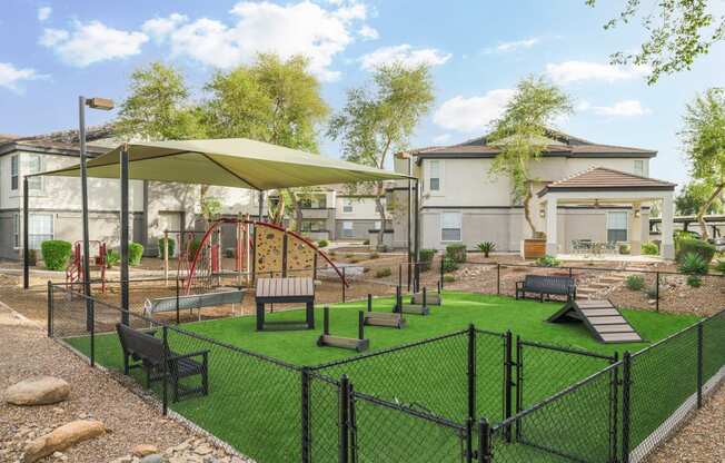 a fenced in play area with benches and umbrellas
