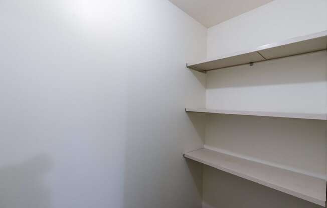 a room with white walls and shelves on the wall. Fargo, ND Windsor Apartments
