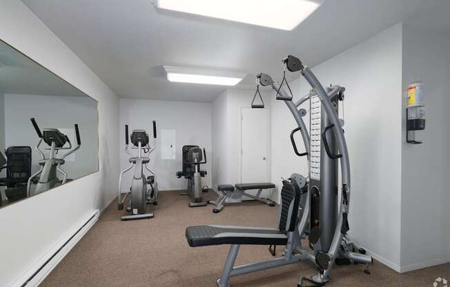 a gym with exercise machines and a mirror