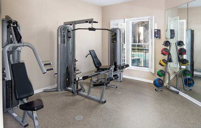 A home gym with a mirror, weights, and exercise equipment.