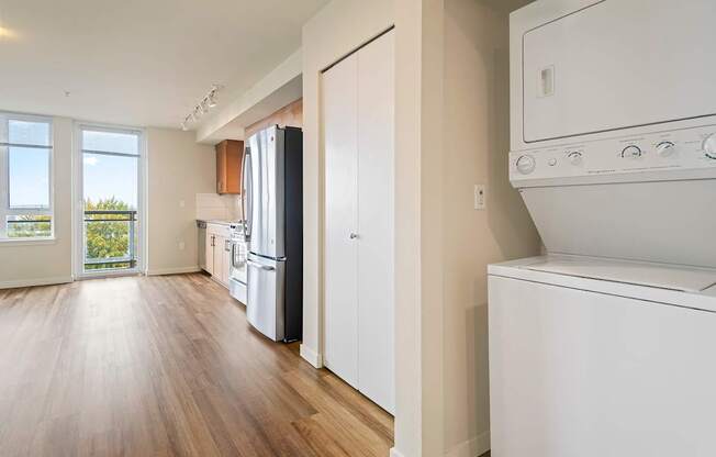 A kitchen with white appliances and wooden floors.