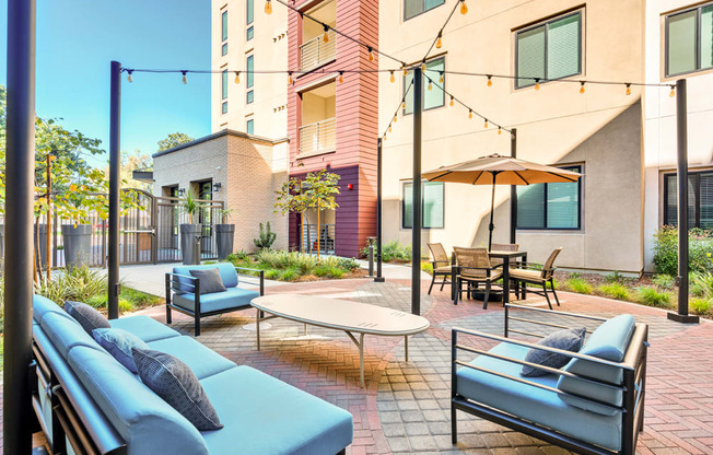 A patio with a table and chairs is surrounded by a brick wall.