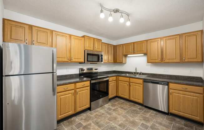 a kitchen with wooden cabinets and stainless steel appliances